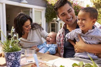 Family At Home Eating Outdoor Meal In Garden Together