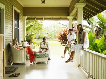 Group of friends sitting on front porch laughing