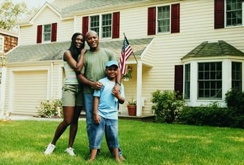 Portrait of a Family Standing on a Lawn in Front of their Home