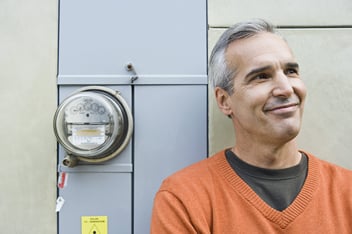 Smiling man beside electric meter