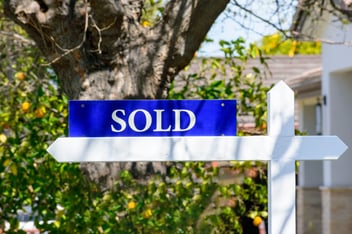 Sold real estate sign on wooden post