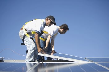 Two men lifting a solar panel