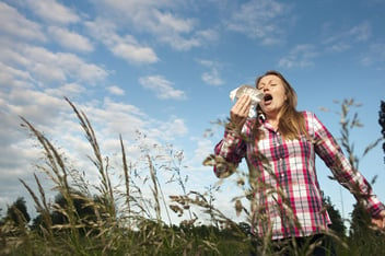 Woman sneezing in tall grass