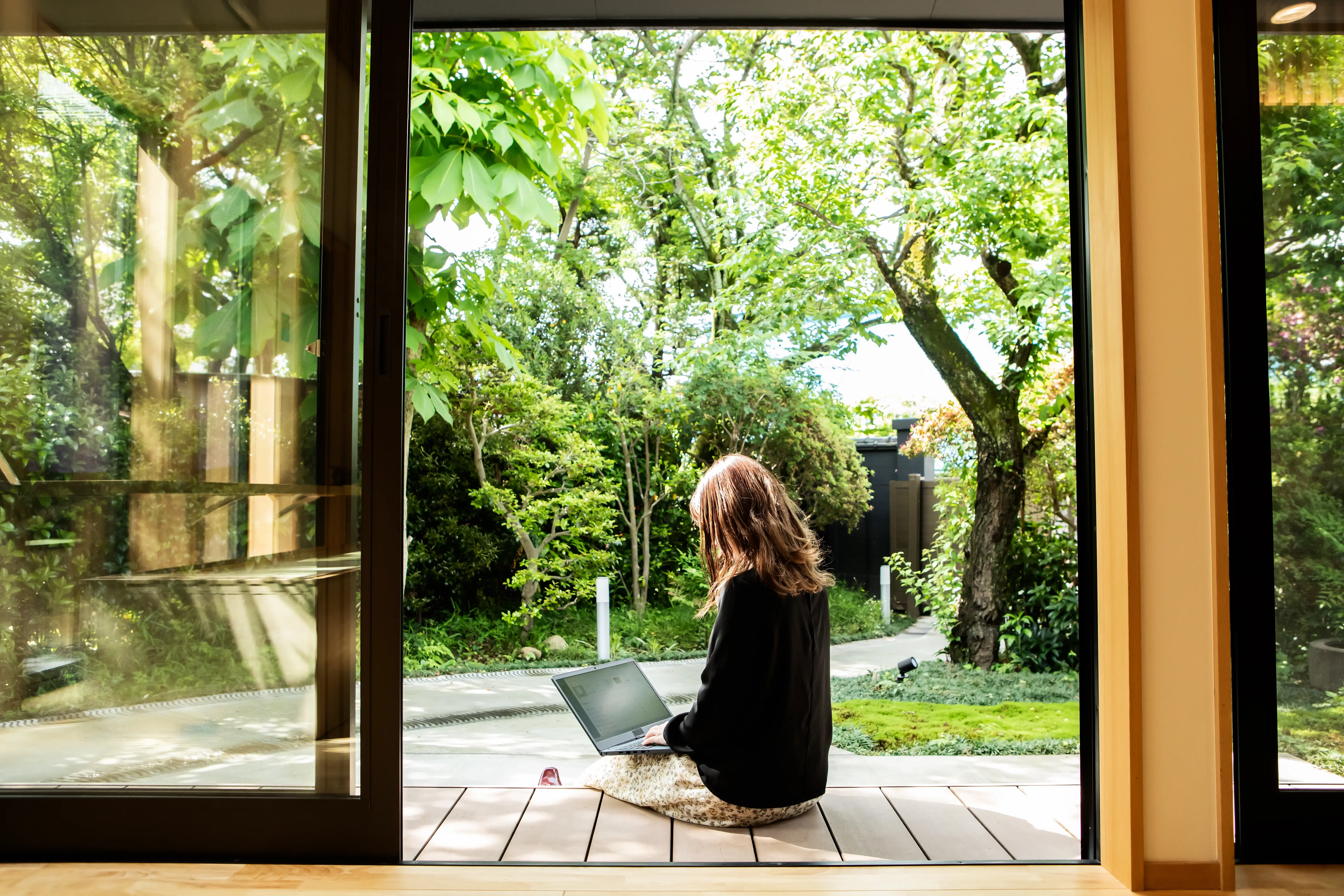 A female guest working on the porch of the guesthouse where she stayed during her trip to Japan.