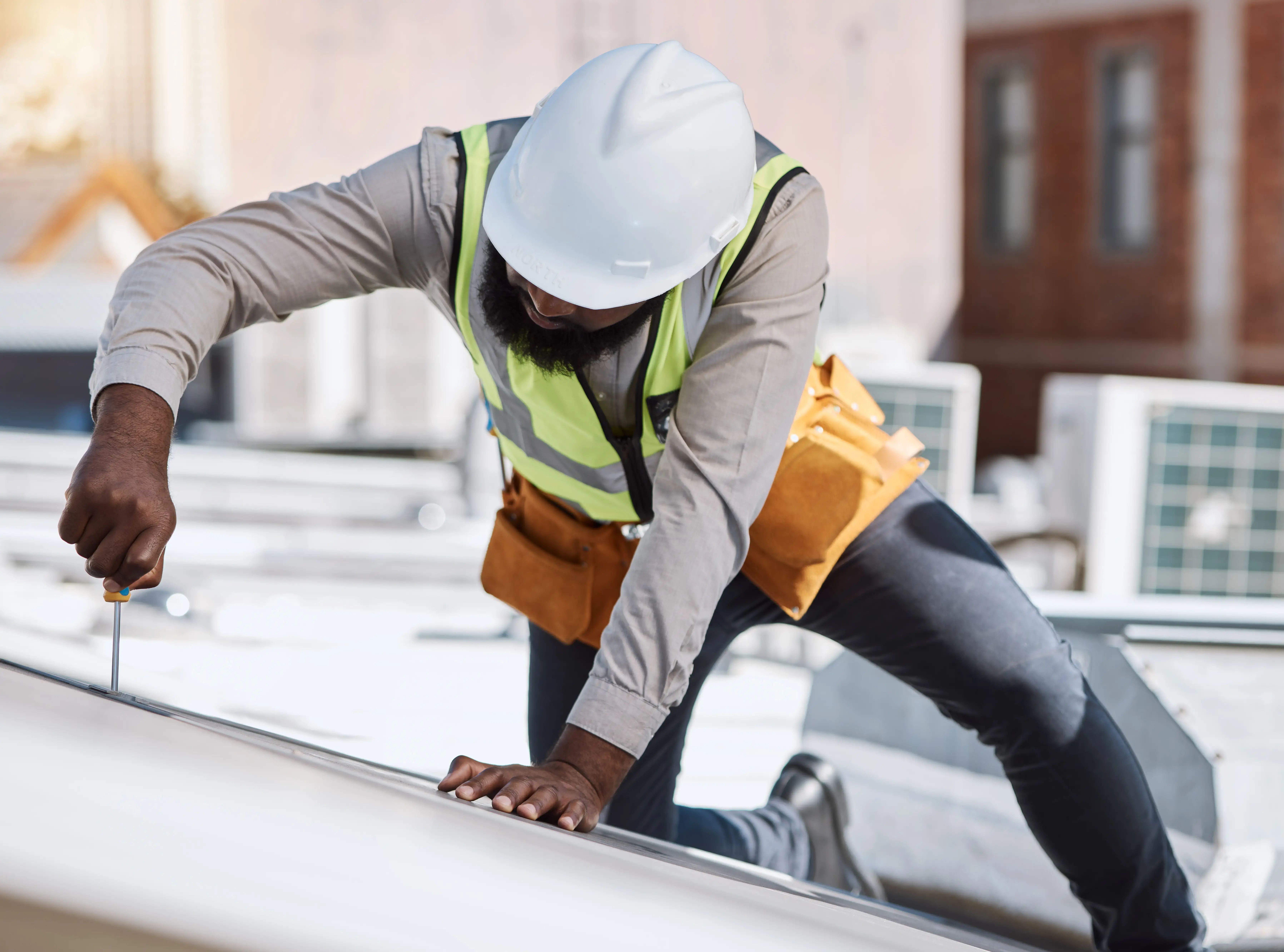 African engineer man, screwdriver and solar energy on rooftop, maintenance and industry for thinking in city. Technician, builder and tools for photovoltaic tech, helmet and sustainability in metro