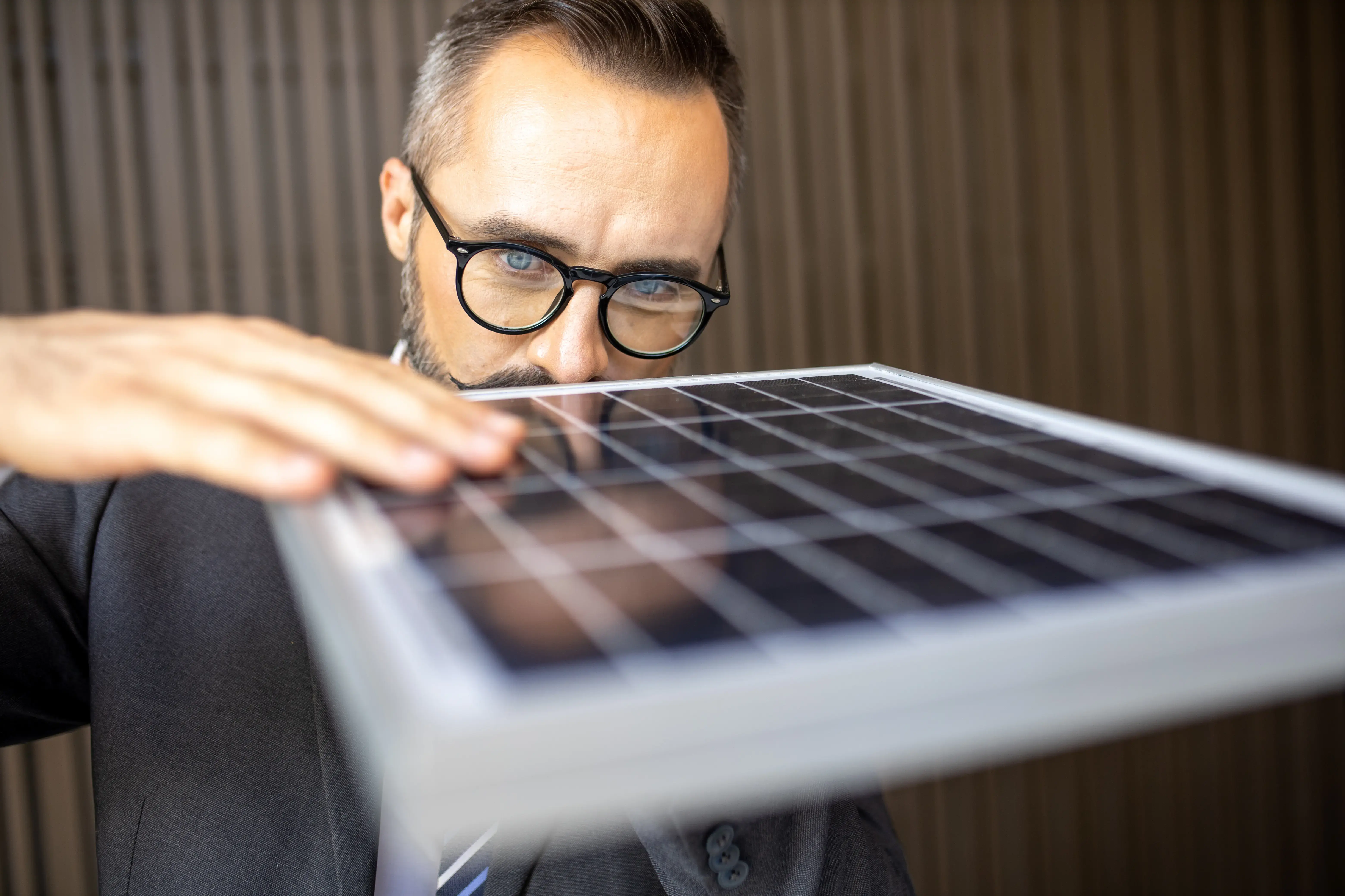 man touching and checking photovoltaic panel while working on solar power station on sunny day. Solar energy concept