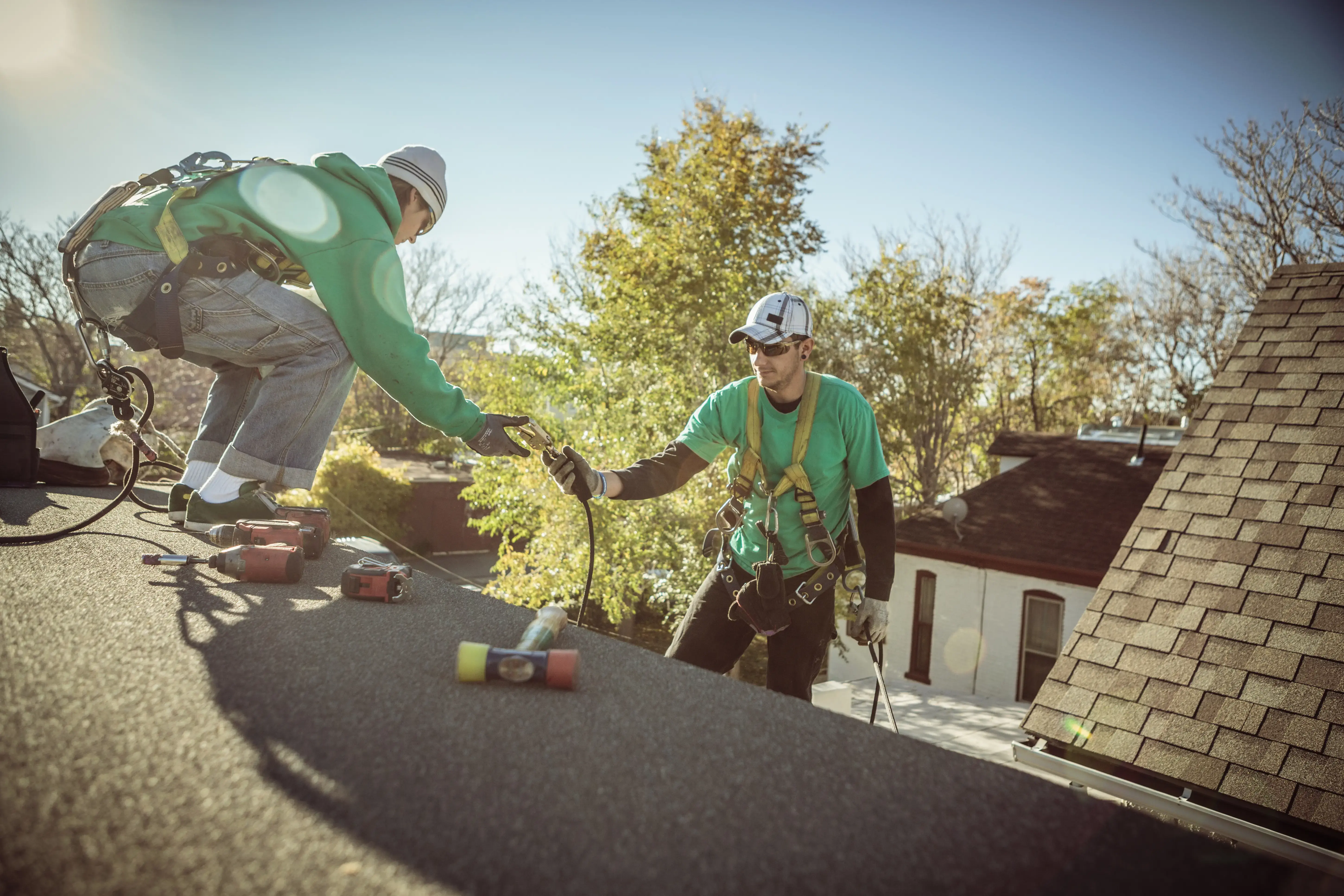 Solar panel installation crew members on roof of house