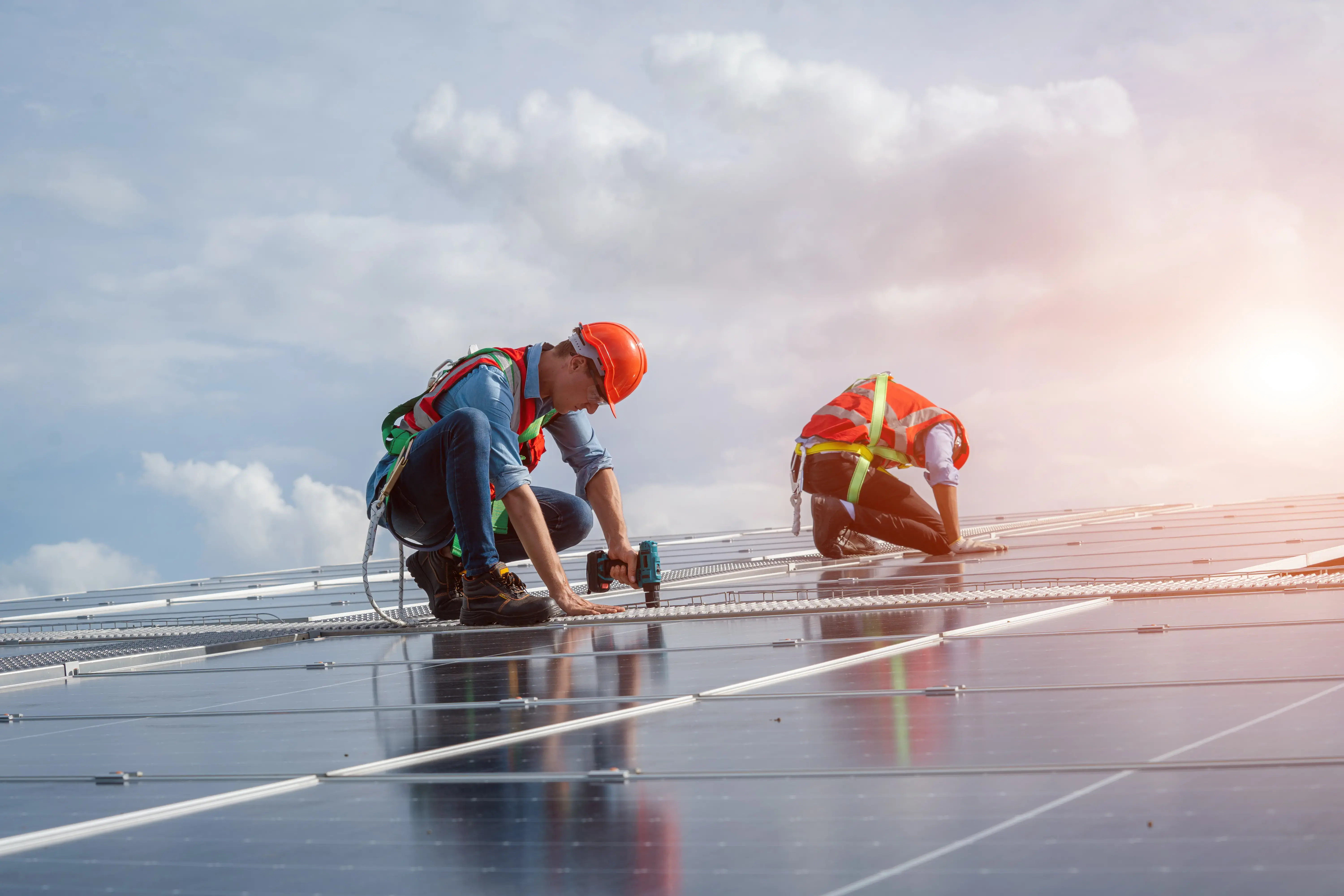 Technician using drill during installing the solar panels.