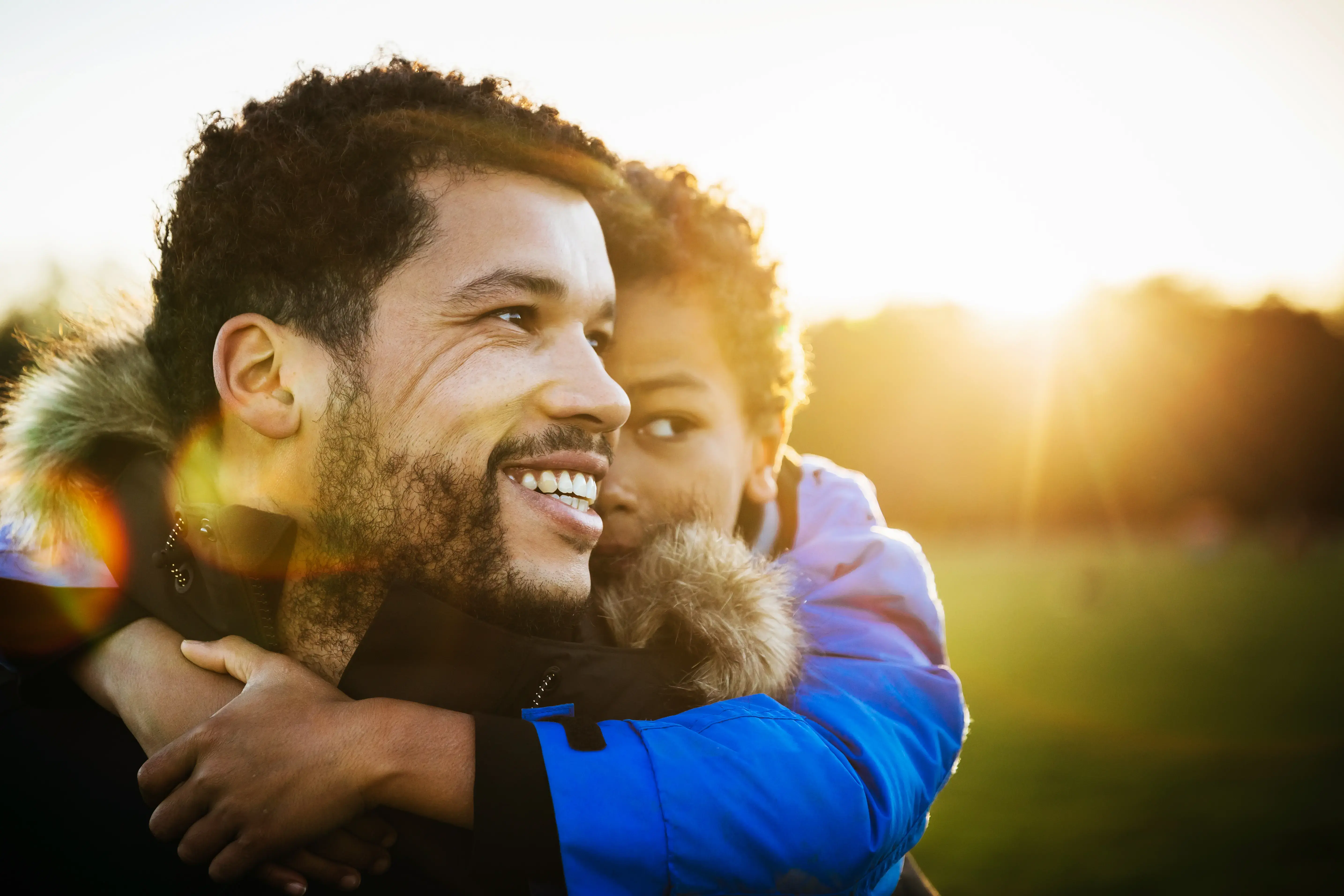 Young Boy Holding Onto His Dad At The Park