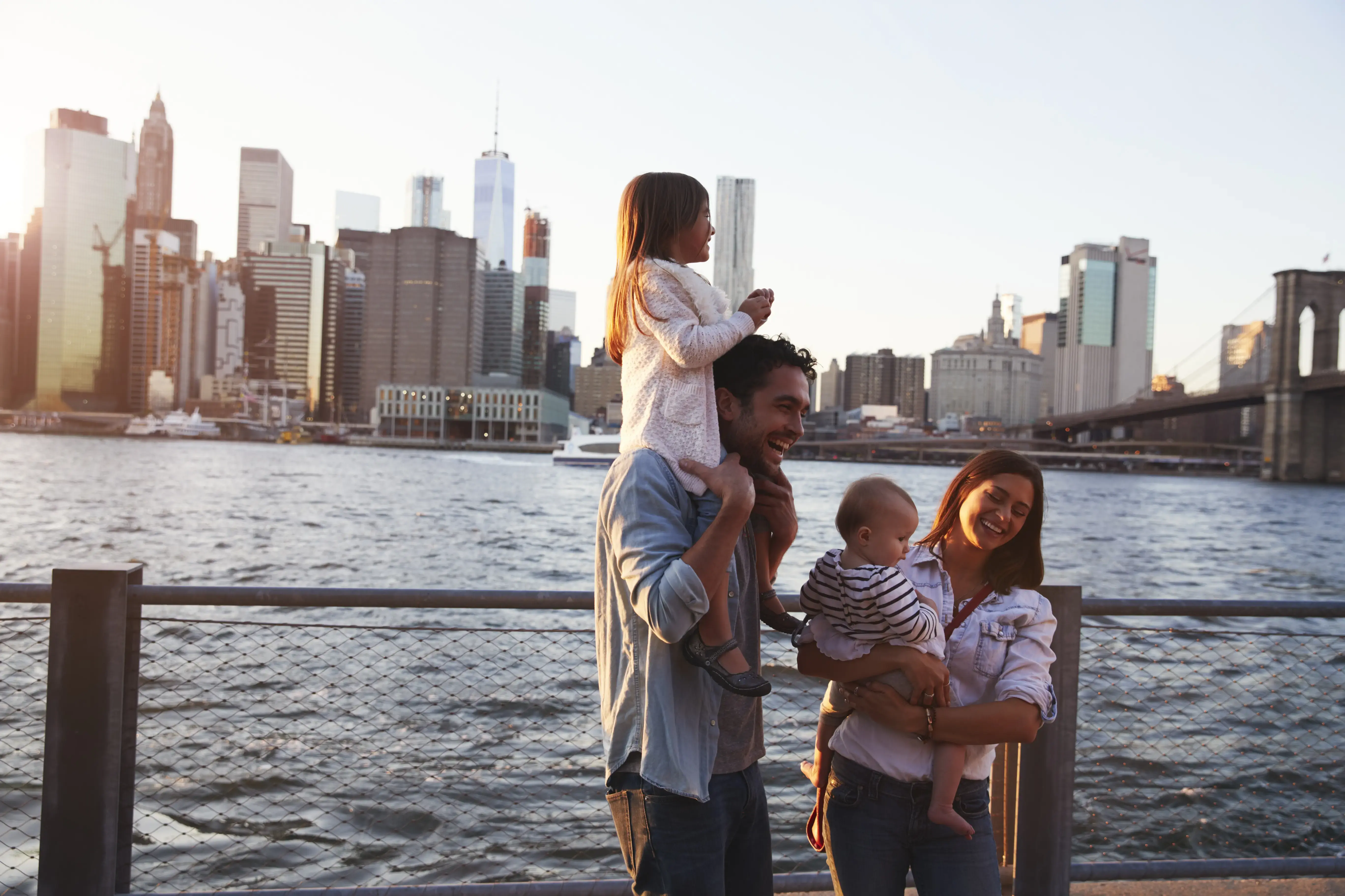 Young family with daughters standing on quayside, side view