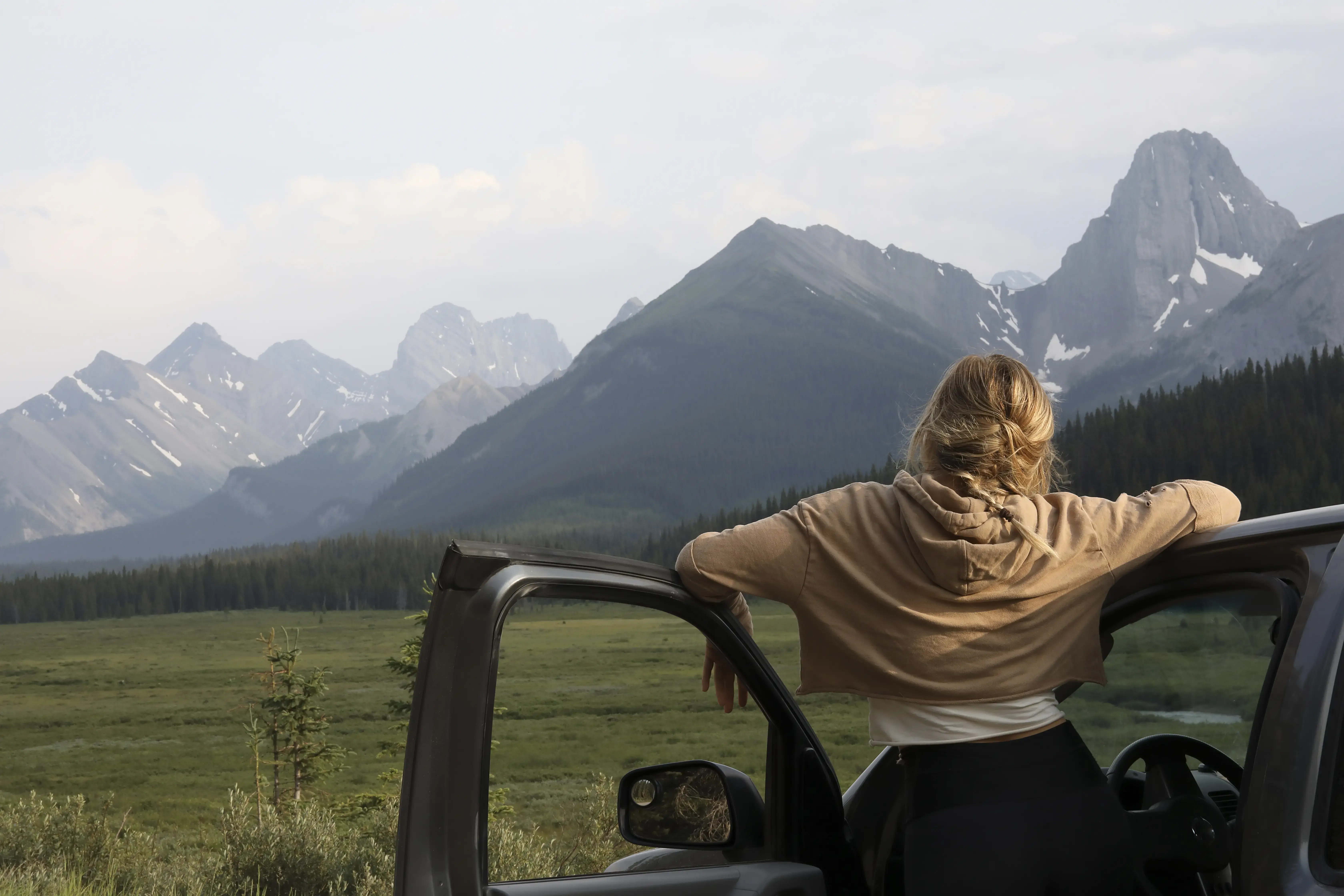 Young woman stops driving to relax and enjoy the view